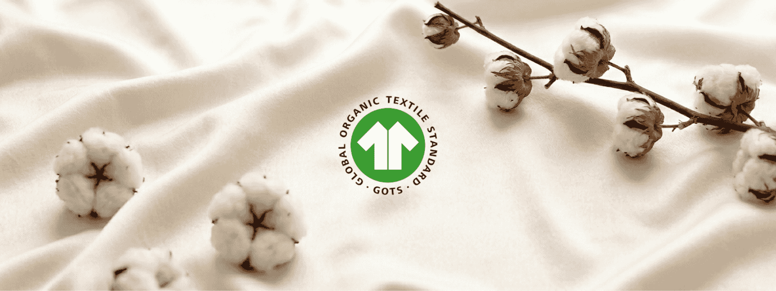 What Is GOTS Certification for Textiles and Why Should You Care? - Orchids Lux Home Cotton balls on soft fabric with GOTS logo representing GOTS certification for organic textiles.