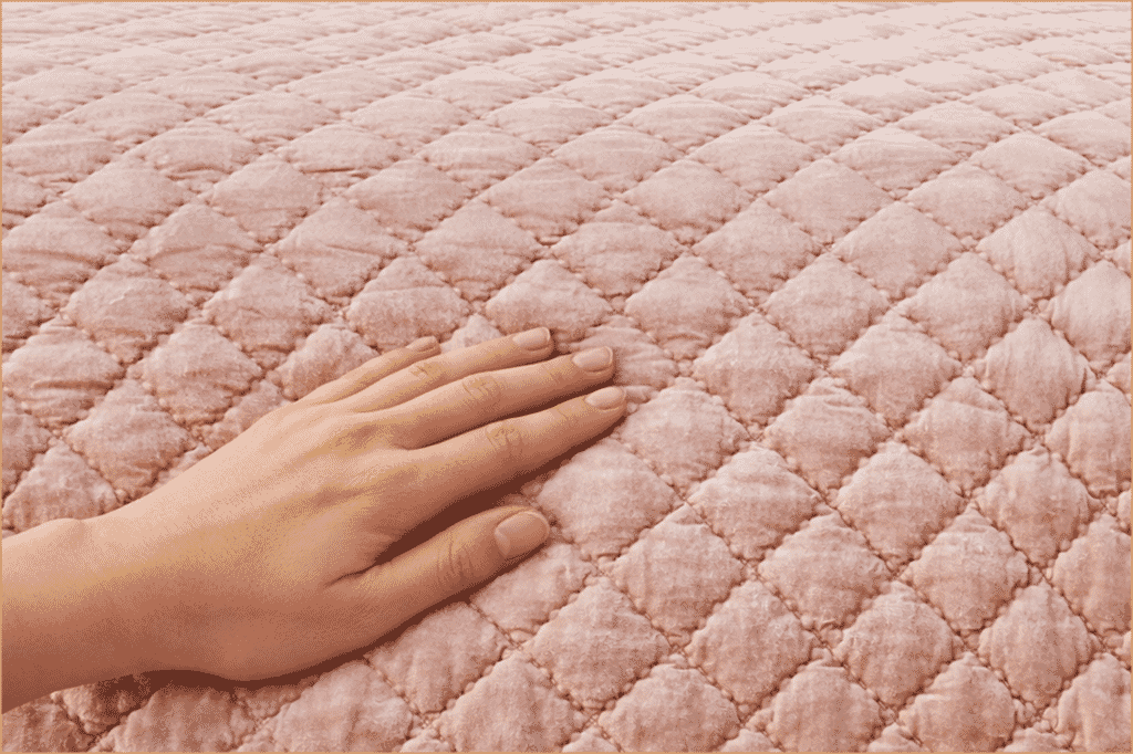 Why Velvet Quilt Is More Versatile Than You Think? - Orchids Lux Home Hand resting on a rose-colored velvet quilt, highlighting the quilted texture and soft pile.
